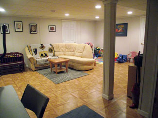 New walls, dropped ceiling, recessed lighting, and vinyl flooring has transformed it to an inviting, multi-purpose family room.